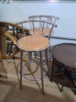 A pair of modern chrome plated bar stools