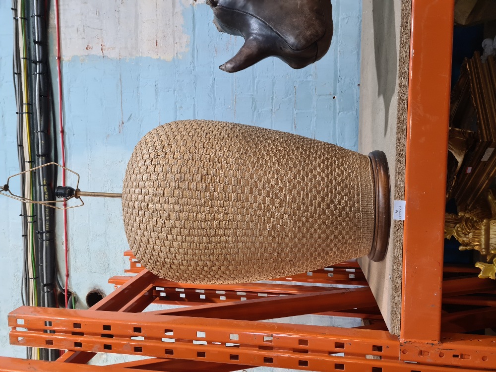 A large cane covered lamp on wooden base