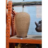 A large cane covered lamp on wooden base