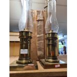 A pair of brass plated storm lanterns with extra funnels