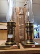 A pair of brass plated storm lanterns with extra funnels