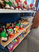 M & M's, a shelf of collectables to include tins, mugs, figures and similar