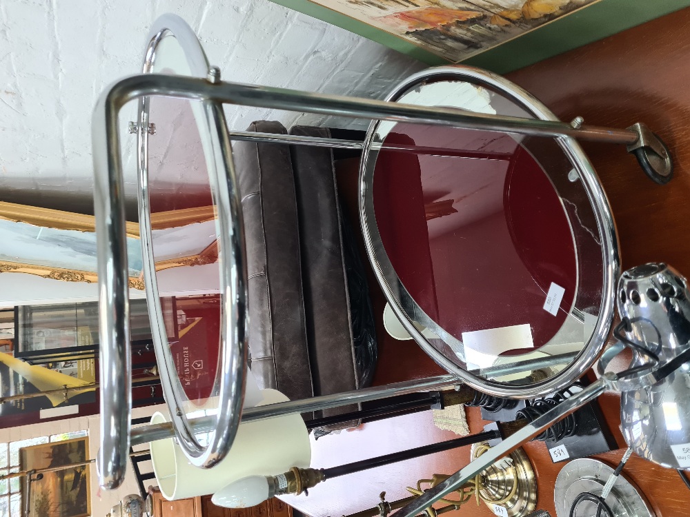 A vintage chrome two tier tea trolley of oval form