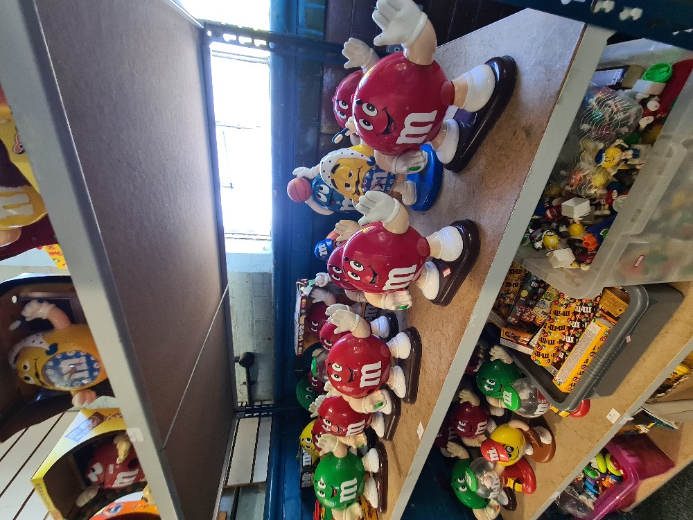 M & M's, a shelf of large figure dispensers and similar