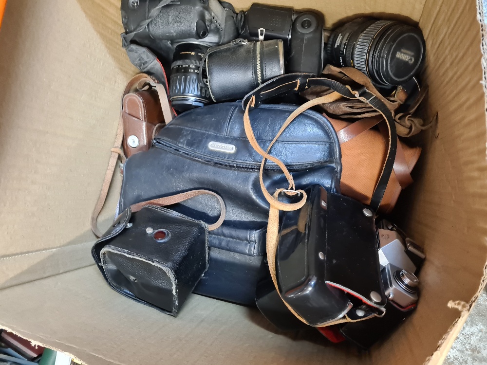 A box of vintage cameras, lenses and similar
