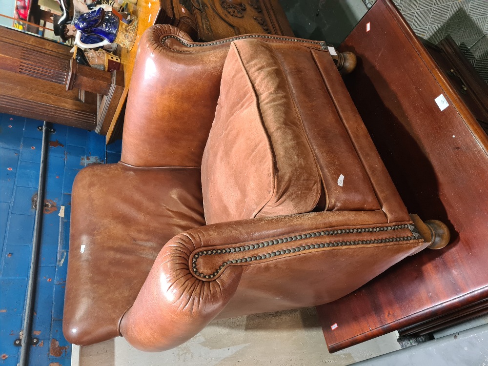 A 1930s style leather armchair having fabric cushion