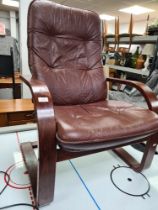 A vintage style armchair with brown faux leather upholstery
