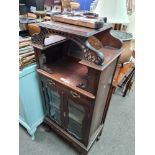 An early 20th Century pillar display cabinet having mirror panels, a three drawer sidetable and an E