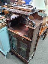 An early 20th Century pillar display cabinet having mirror panels, a three drawer sidetable and an E