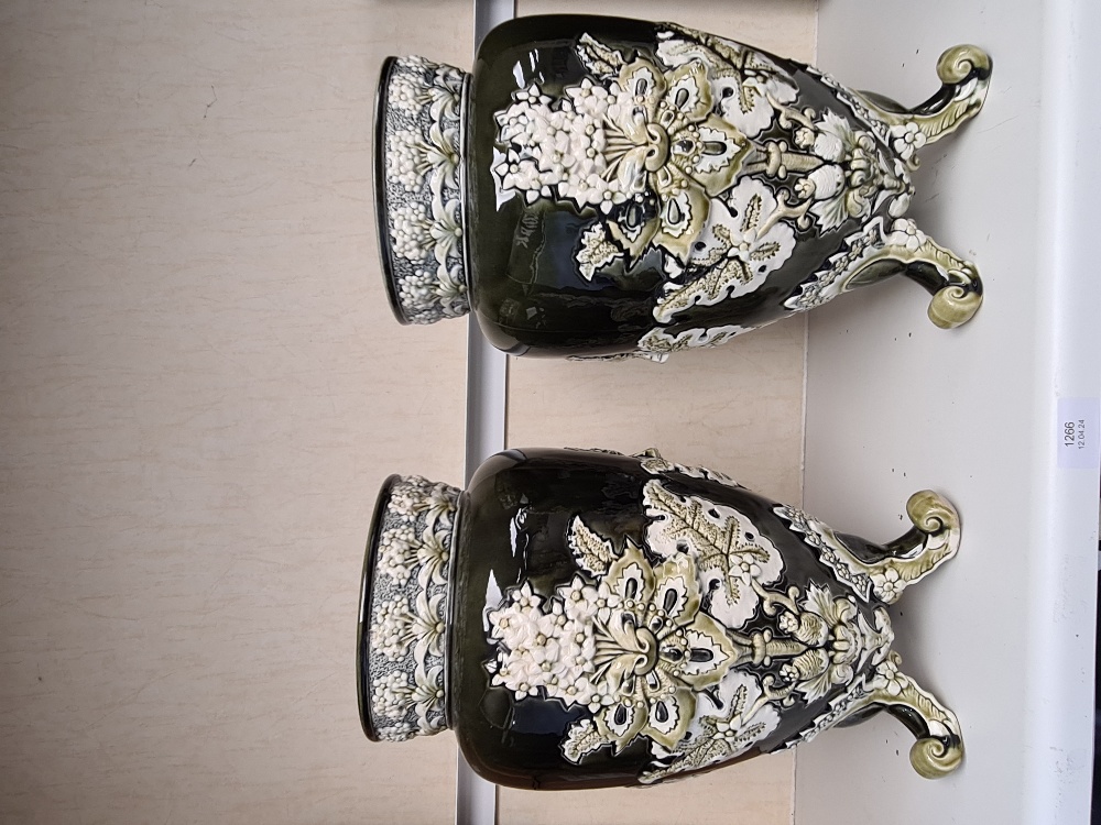 A pair of early 20th Century vases having raised floral decoration on three feet, 37.5cms