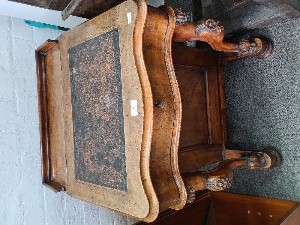 A Victorian walnut Davenport having four side drawers and carved scroll supports