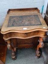 A Victorian walnut Davenport having four side drawers and carved scroll supports