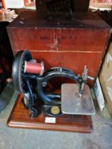 An antique Willcox and Giggs sewing machine in wooden case