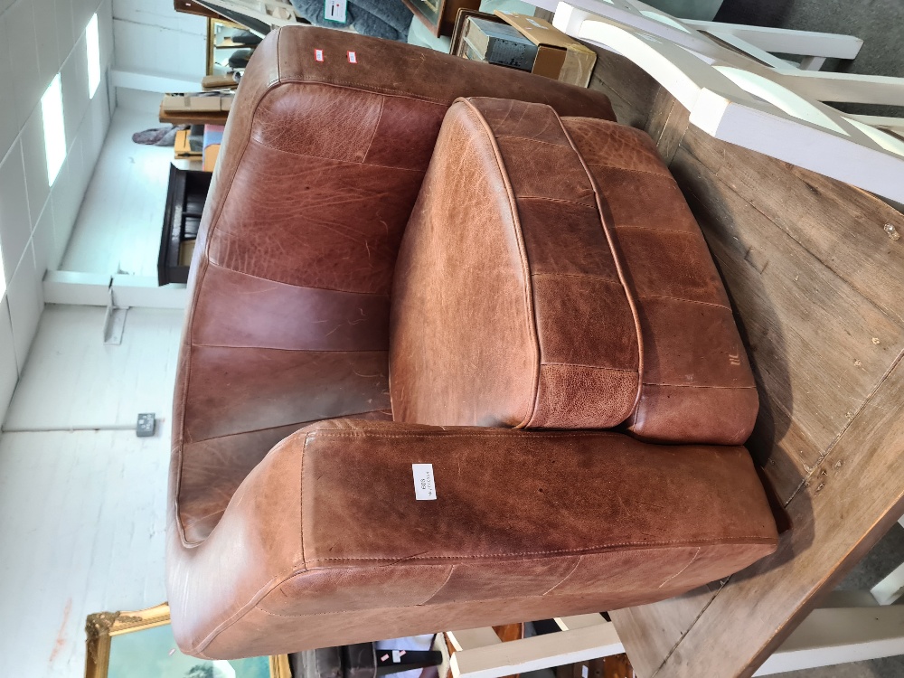 A modern brown leather tub armchair