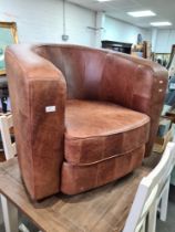A modern brown leather tub armchair