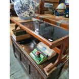 A G-Plan style 1970s coffee table having tile and smokey glass top, 121cm