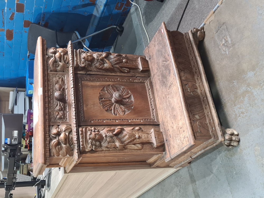 An antique carved walnut prayer kneeler/ Pri Dieu, probably Spanish, having central cupboard flanked