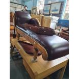 A reproduction Regency style chaise longue having brown leather cover