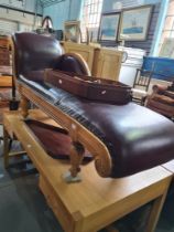 A reproduction Regency style chaise longue having brown leather cover