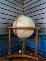 A reproduction illuminated globe on wooden stand, height 78cms