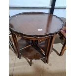 A reproduction mahogany circular coffee table with 4 quartr tables
