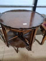 A reproduction mahogany circular coffee table with 4 quartr tables
