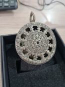 An Eastern White metal hanging religious pendant having pierced cover