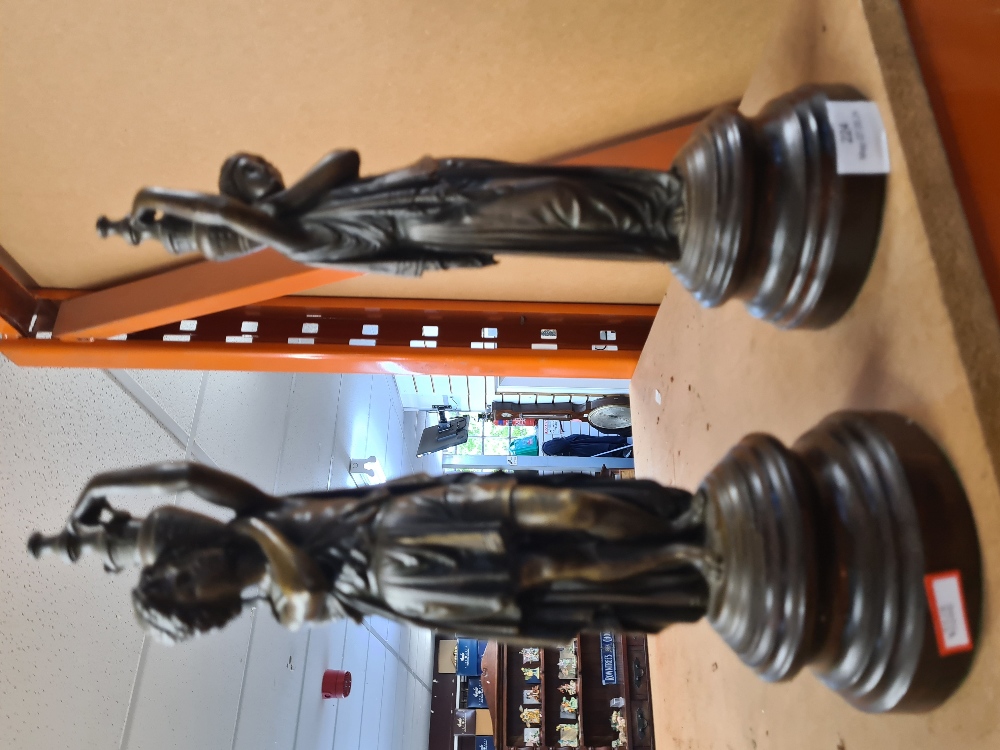 A pair of 19th Century style bronzed figures holding urns, 36cm