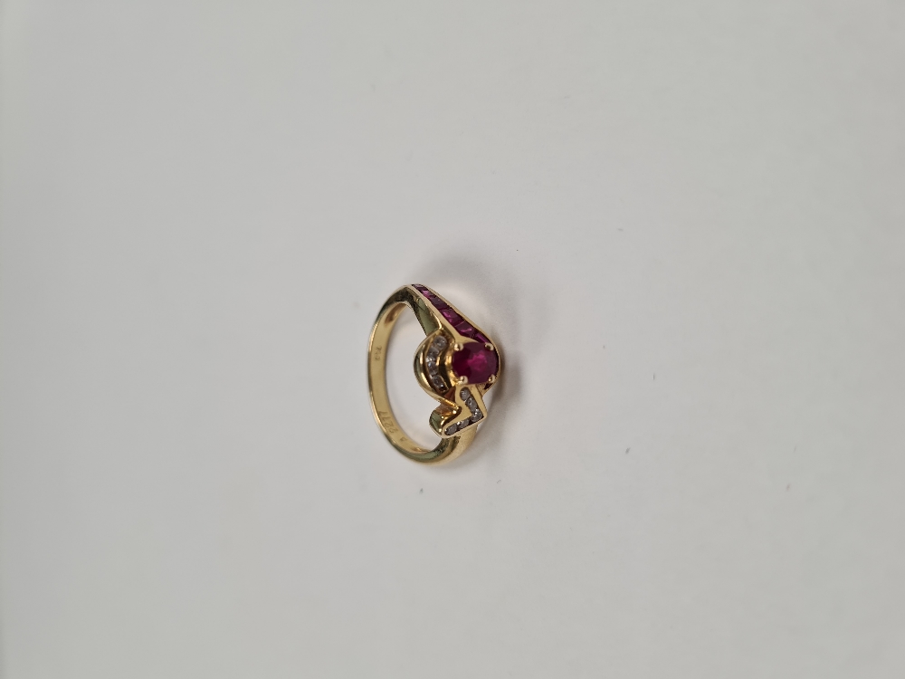 18ct yellow gold ruby and diamond crossover design dress ring, set central oval cut ruby, surrounded