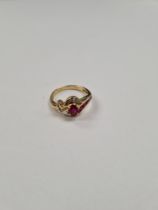 18ct yellow gold ruby and diamond crossover design dress ring, set central oval cut ruby, surrounded