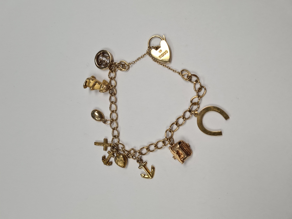9ct yellow gold charm bracelet 8 gold charms, all 9ct gold including typewriter, horse shoe, anchor,