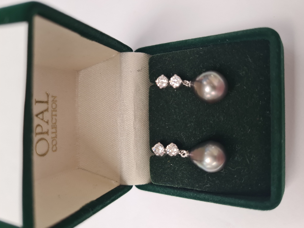 Pair of elegant 18K white gold earrings, each with a large cultured pear shaped South Sea pearl hung