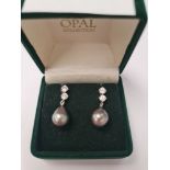 Pair of elegant 18K white gold earrings, each with a large cultured pear shaped South Sea pearl hung