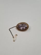 Antique 9ct yellow gold oval brooch, with large oval mixed cut amethyst, in 9ct 4 claw mount framed