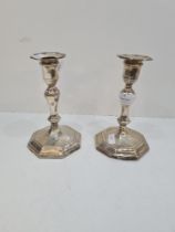 A pair of Hawksworth Eyre and Co Ltd silver candlesticks, having octagonal moulded pedestal bases, o