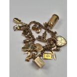 18ct gold bracelet hung with 23 charms, including 9ct and yellow metal, 9ct front and back locket, 9