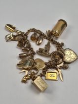 18ct gold bracelet hung with 23 charms, including 9ct and yellow metal, 9ct front and back locket, 9