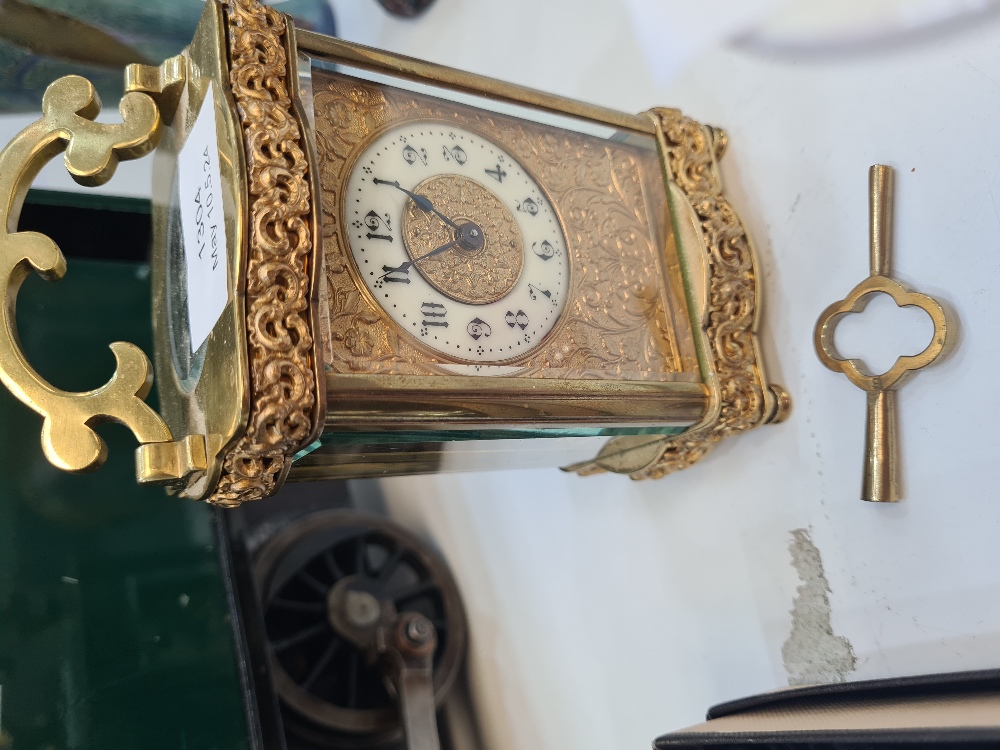 A French brass carriage clock having floral and scroll decoration