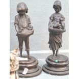 A pair of bronze sculptures of boy and girl with puppies and kittens on round base, stamped Lancini,