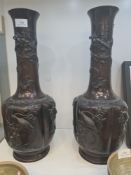 A pair of Japanese bronze vases, decorated birds and dragons, 46.5cms