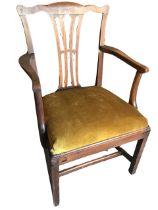 An eighteenth century elm elbow chair with pierced splat and shaped arms above a drop-in upholstered
