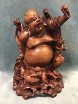 A Chinese carved wood seated laughing buddha with five children representing the elements of fire,