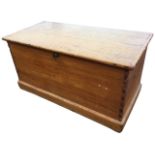 A Victorian pine blanket box of dovetailed construction with brass escutcheon, supported on plinth