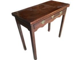 A Georgian mahogany turn-over-top tea table, the twin single piece tops above a long frieze drawer
