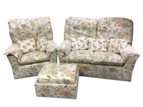 An floral cotton upholstered two-seater sofa, armchair, and pouffe, the rectangular seats with loose