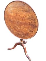 A Georgian mahogany circular occasional table, the tray top tilting on a turned column, raised on