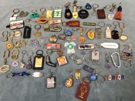 A collection of keyrings in wood, metal, perspex, plastic, lacquer, leather, enamel, etc., including