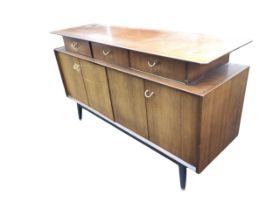 A mid-century G-Plan mahogany sideboard by E Gomme, the rectangular top overhanging three recessed