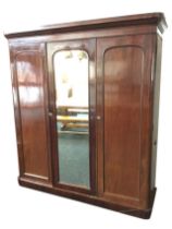 A Victorian mahogany wardrobe, with cushion moulded cornice above three rounded panelled doors,