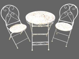 A circular wrought iron folding garden table with pair of matching chairs, the seats and top with